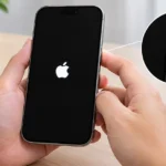 Person force restarting a frozen iPhone 18 by holding the side button until the Apple logo appears